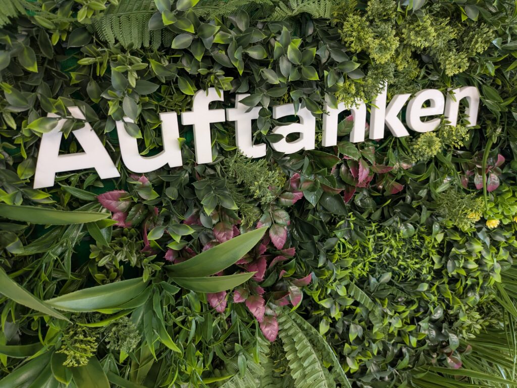 Eine Bepflanzte Wand mit weißen Schriftzug "Auftanken"
